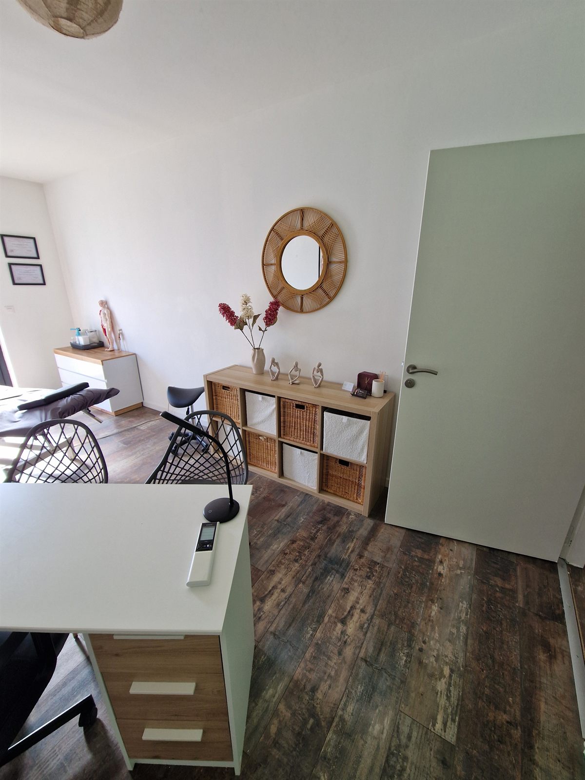 Espace du cabinet : miroir en rotin, rangements et décoration apaisante